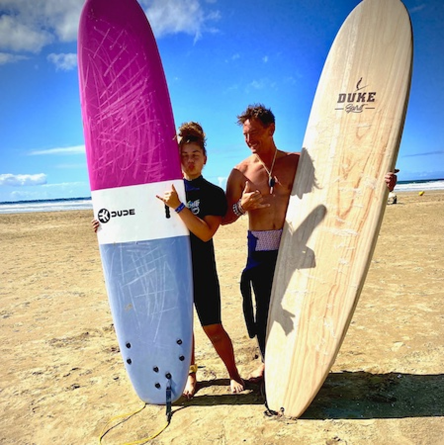 2 personnes debout avec des planches de surf à la main