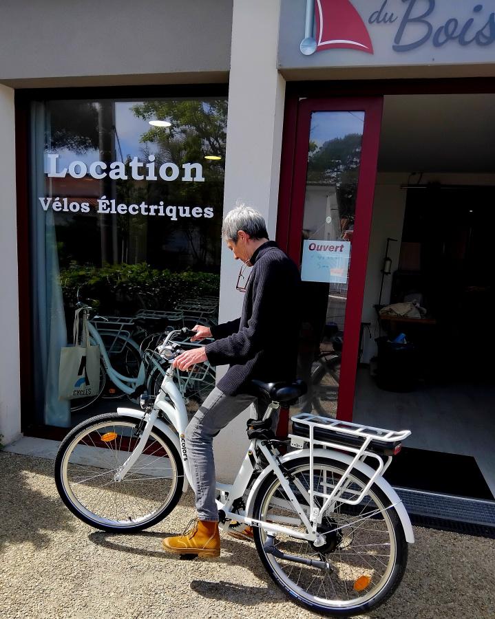 Personne sur un vélo devant l'entrée du magasin