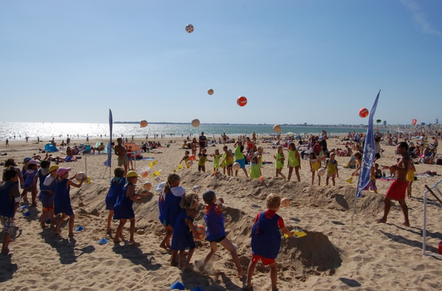 Enfants du club jouant à des activités sur la plage
