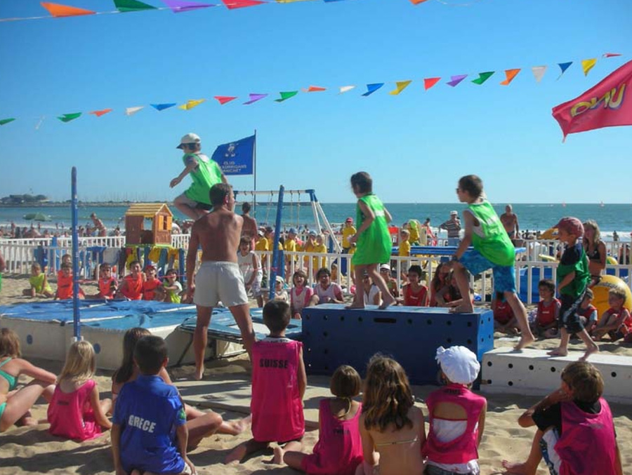 Enfants du club jouant à des activités sur la plage