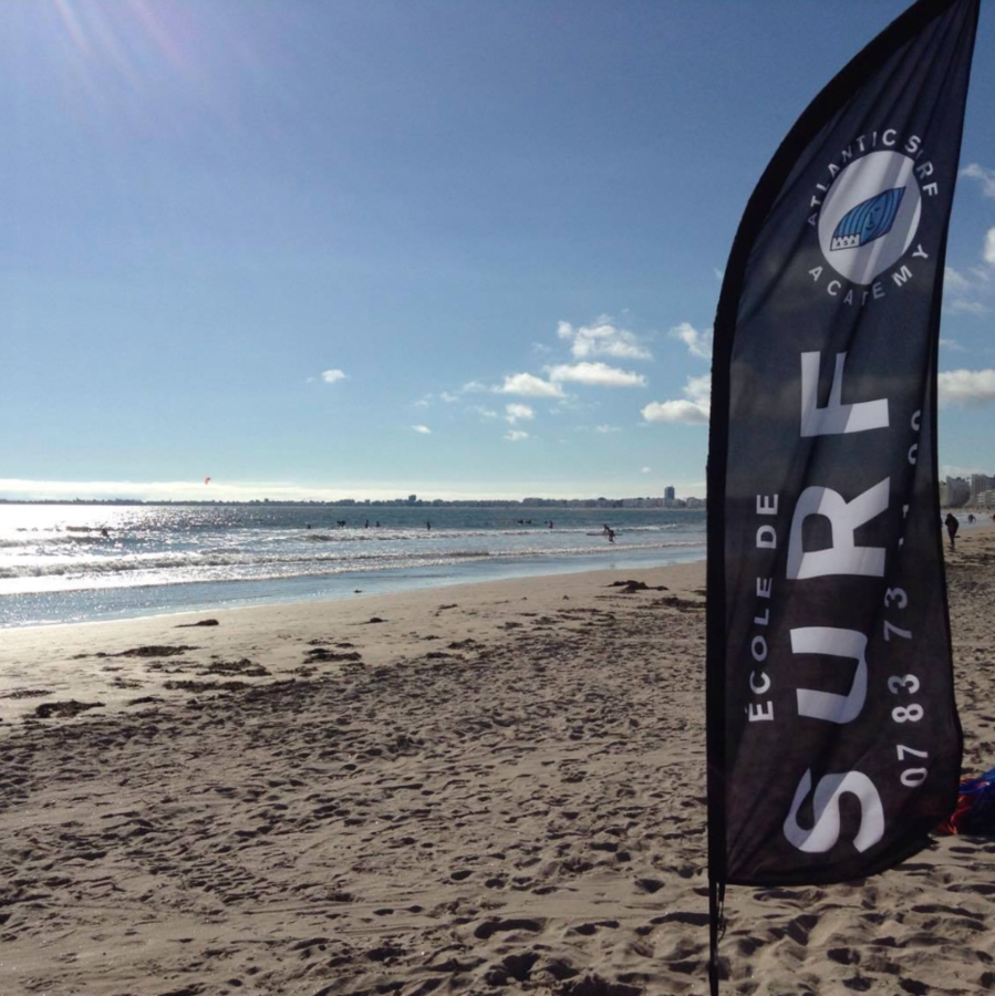 Plage de Saint-Brevin avec oriflamme de l'école de surf planté dans le sable