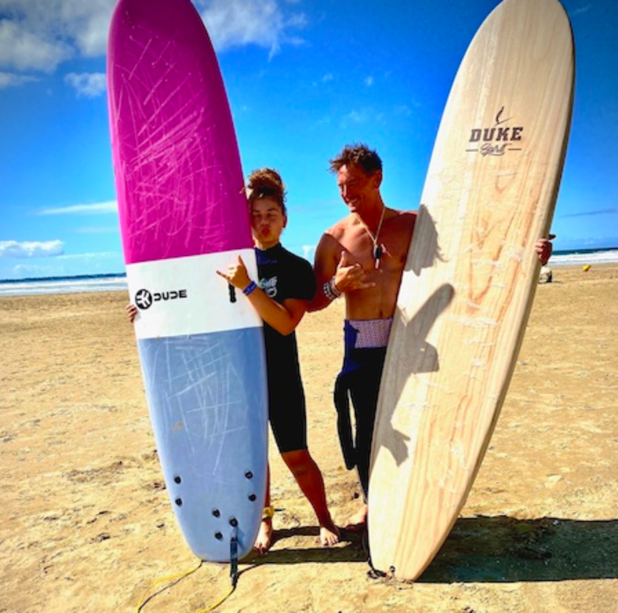 2 personnes debout avec des planches de surf à la main