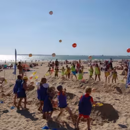 Enfants du club jouant à des activités sur la plage
