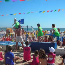 Enfants du club jouant à des activités sur la plage