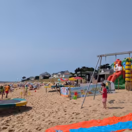 Photo du club avec structure gonflable, balançoires et trampolines.