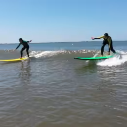 Deux personnes surfant une vague