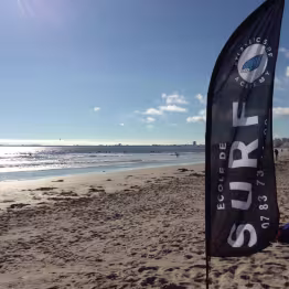Plage de Saint-Brevin avec oriflamme de l'école de surf planté dans le sable
