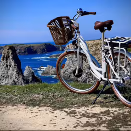 Vélo Locatourisle stationné en bord de côte, vue mer