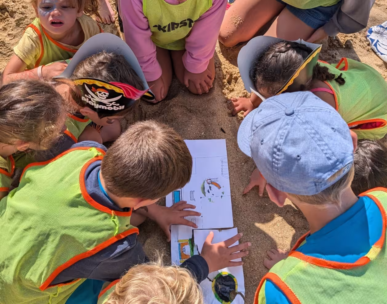 Enfants sur le sable qui regardent une carte